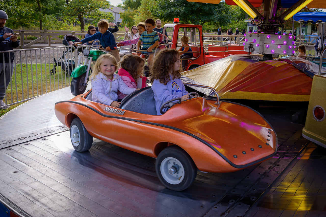 children riding a car-themed carousel