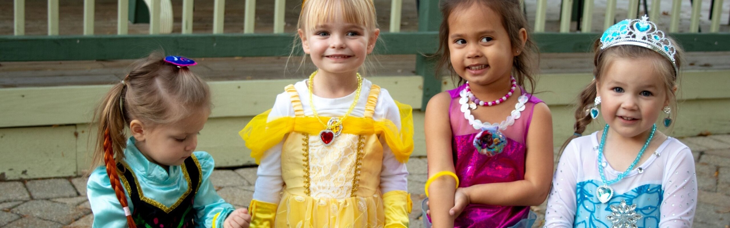 Four little girls dressed up as princesses
