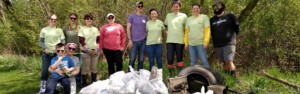 Stream Clean Up Day participants pose with clean up items and garbage bags