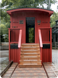 A train caboose stands at a halt on the tracks that run through Cosley Zoo.
